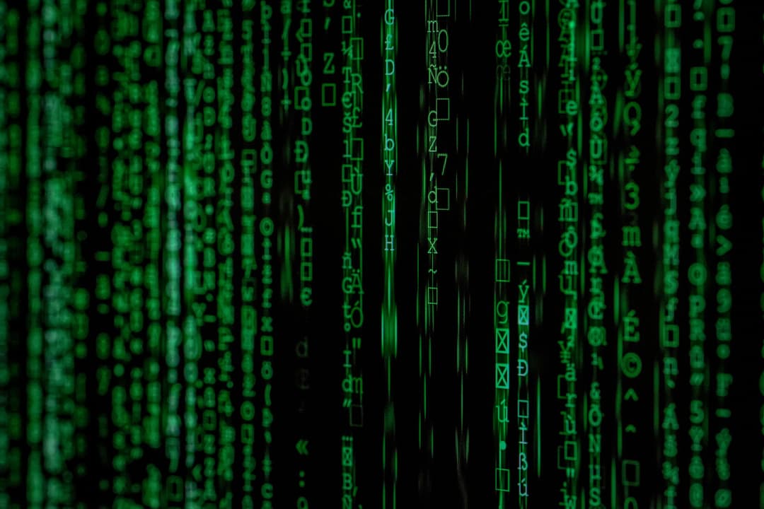 Green cryptic code streams vertically on a black background, resembling the iconic "Matrix" digital rain effect, evoking a cybernetic and mysterious atmosphere.
