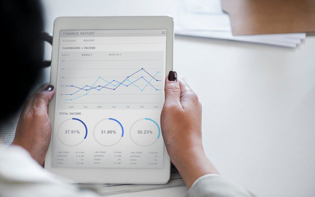 a person holding a tablet with some statistics