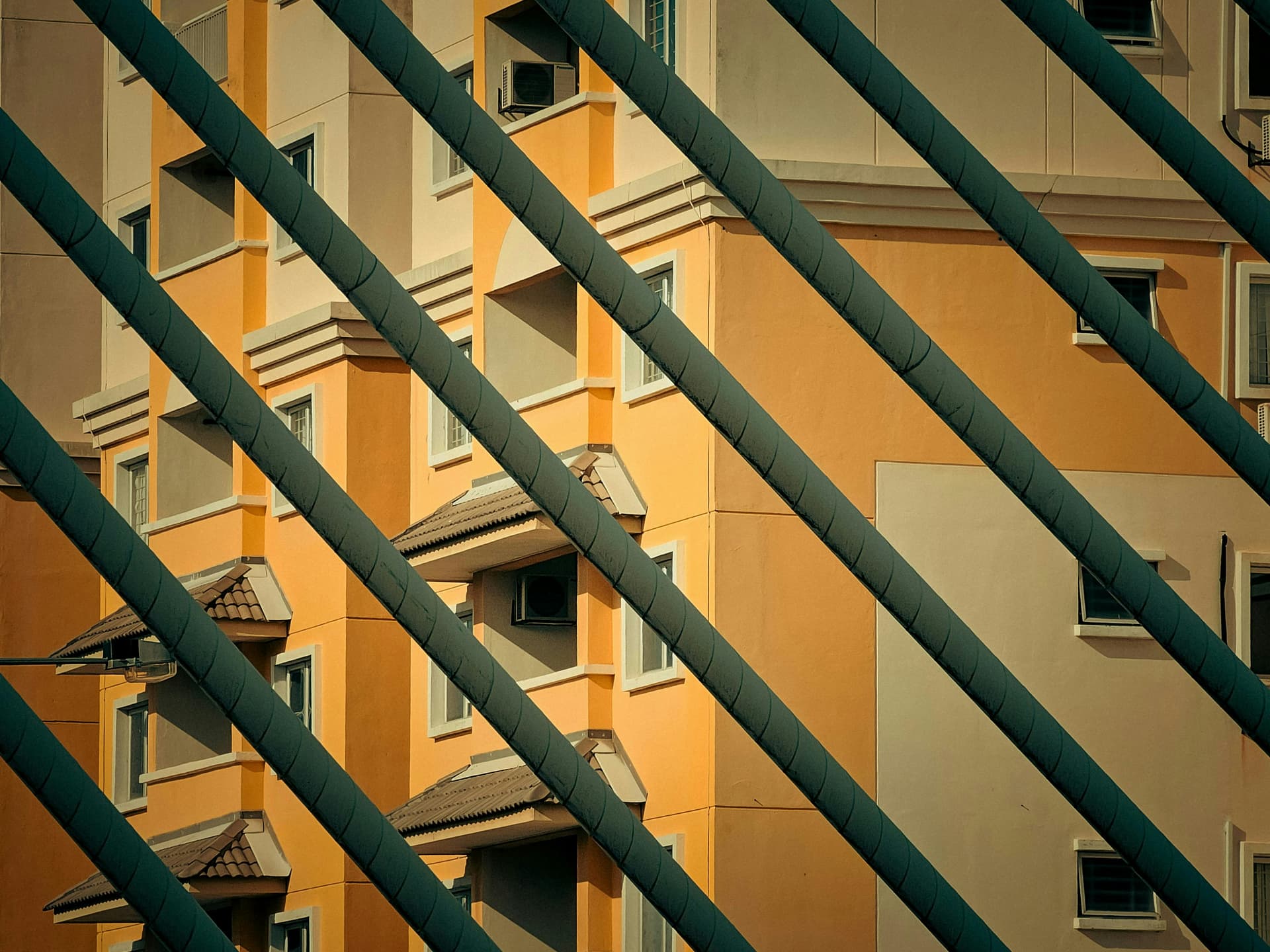A tall building with many windows next to a fence